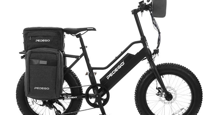 Electric cargo bike with panniers on white studio backdrop