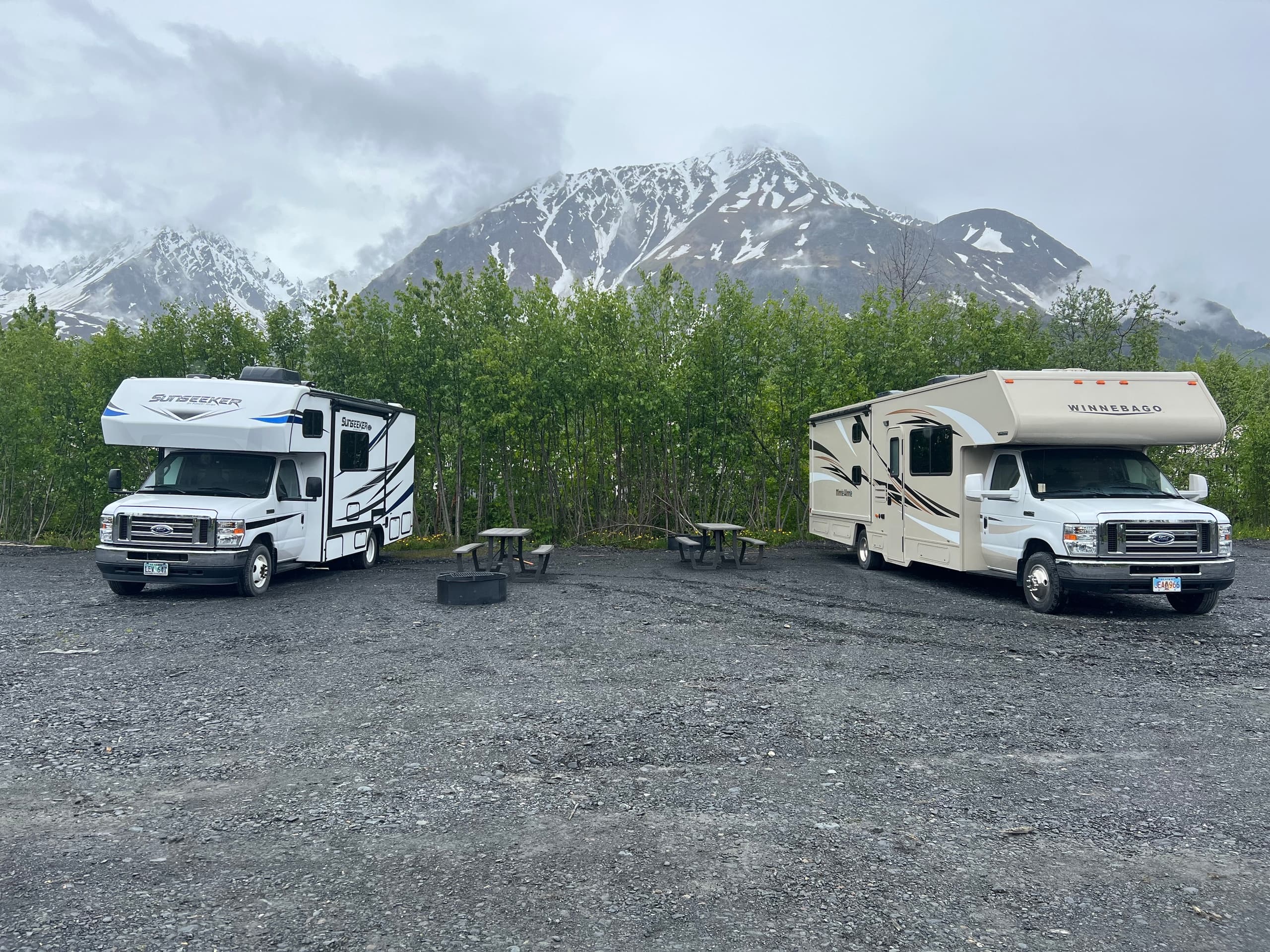 RV campers parked near alpine trees with mountain views Alaska