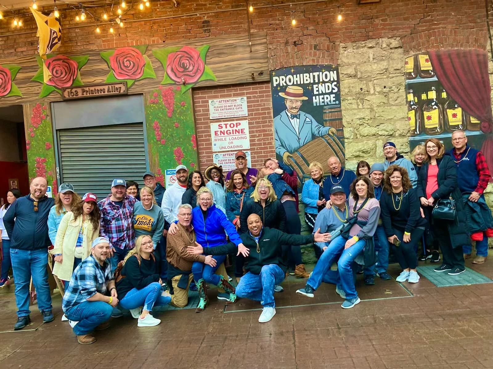 Large group by mural in Nashville alley during guided pub crawl