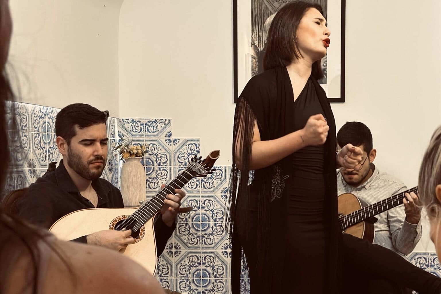 Fado singer performing with guitars in intimate indoor venue