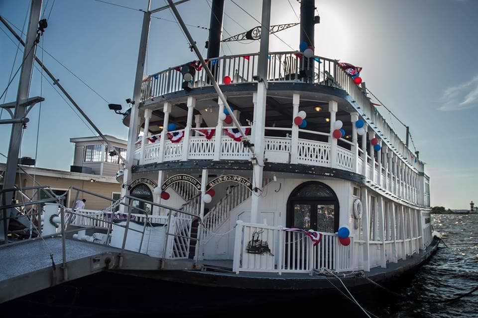 White steamboat docked at pier under clear daytime sky