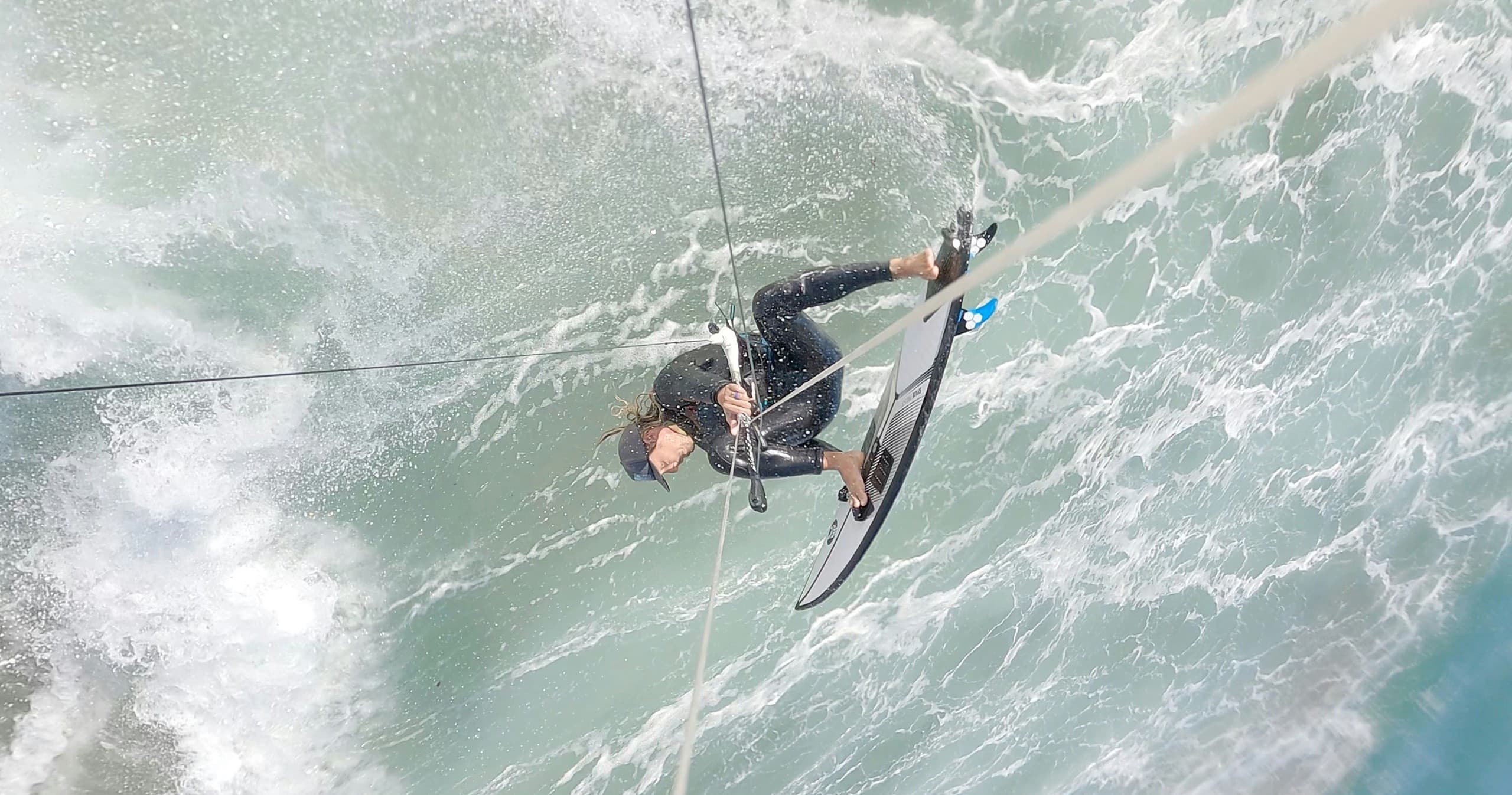Kiteboarder launching into a steep ocean wave in action