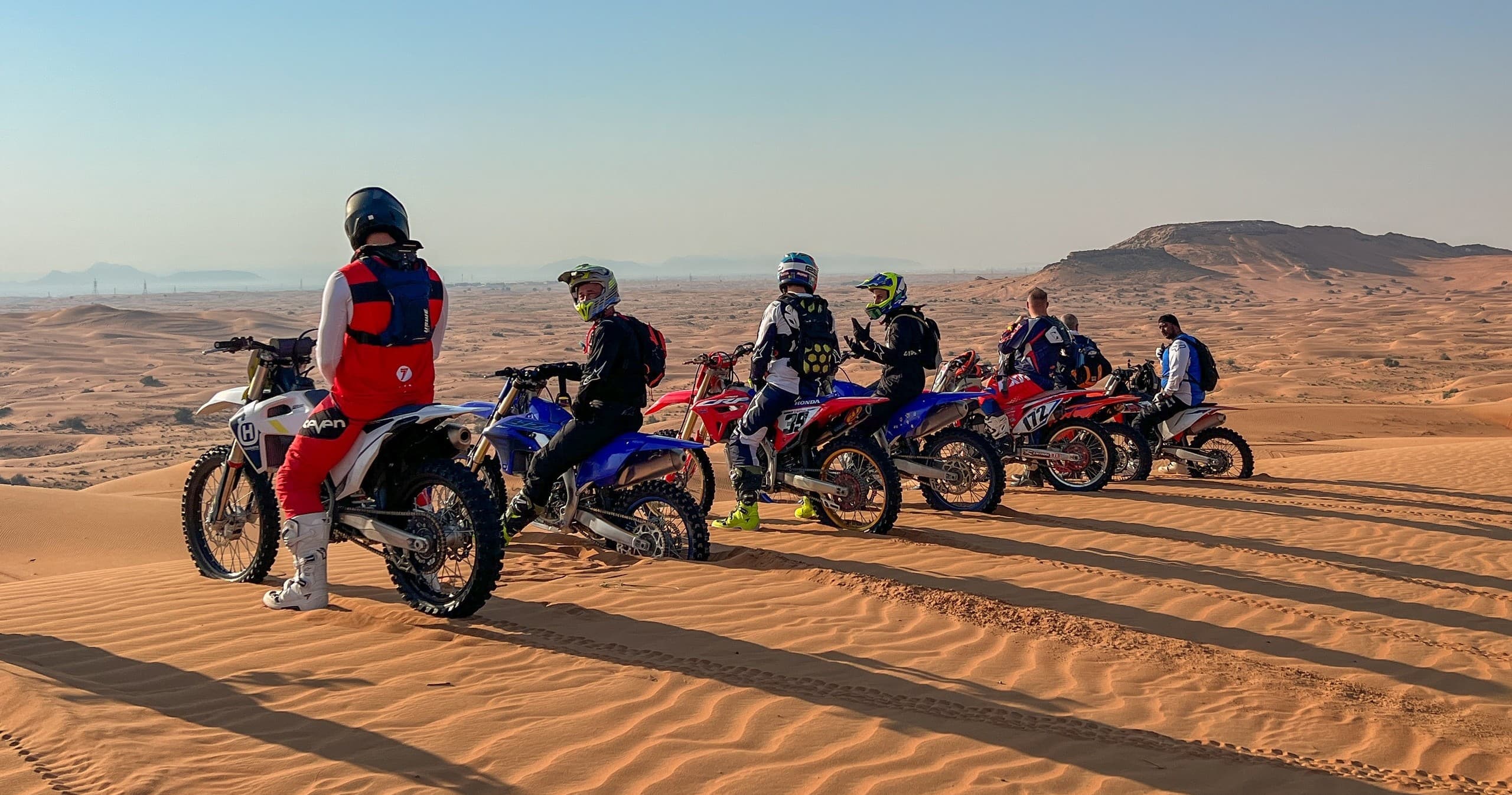 Line of off-road bikes and riders ready on desert trail