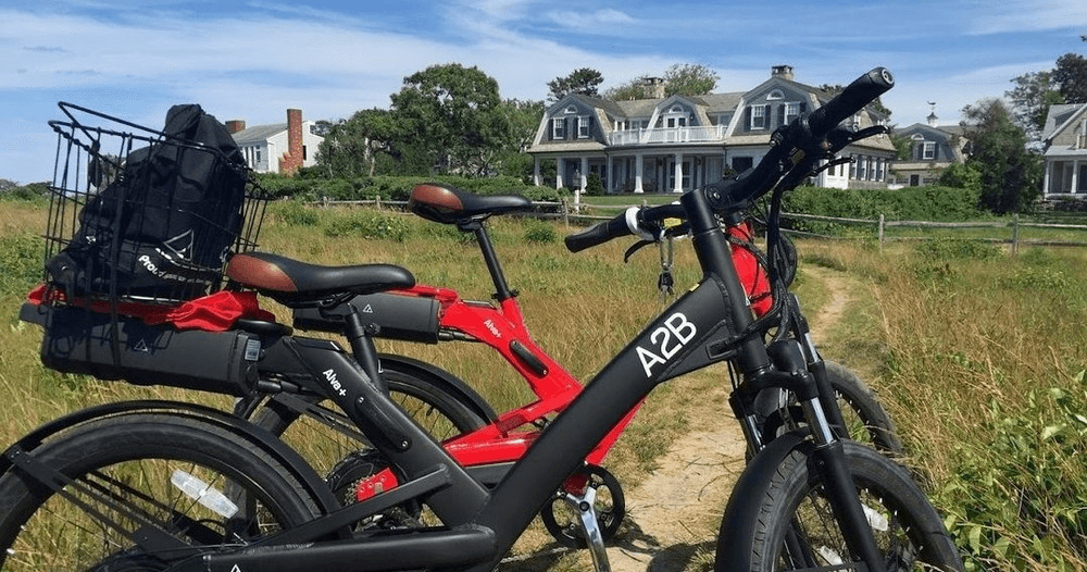 Red electric bike with luggage rack on coastal path at shore