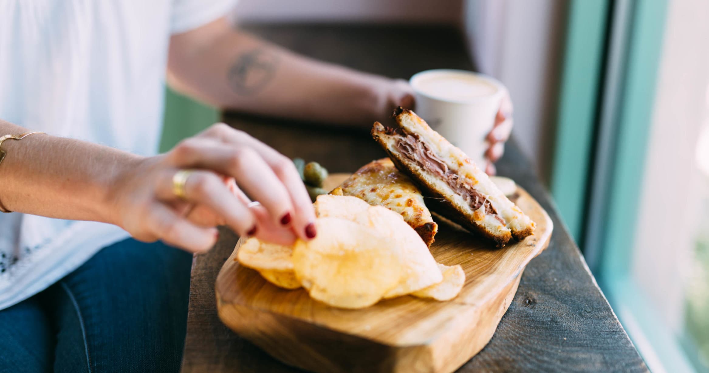 Casual cafe sandwich tasting by window during urban food tour