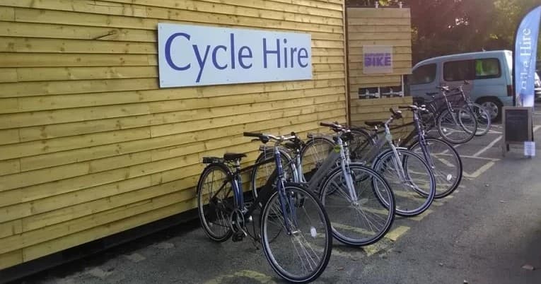 Row of rental bicycles outside wooden cycle hire shop