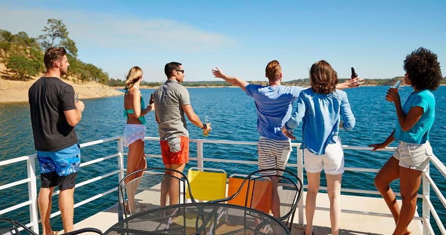 Group on boat bow pointing at Lake Camanche scenery