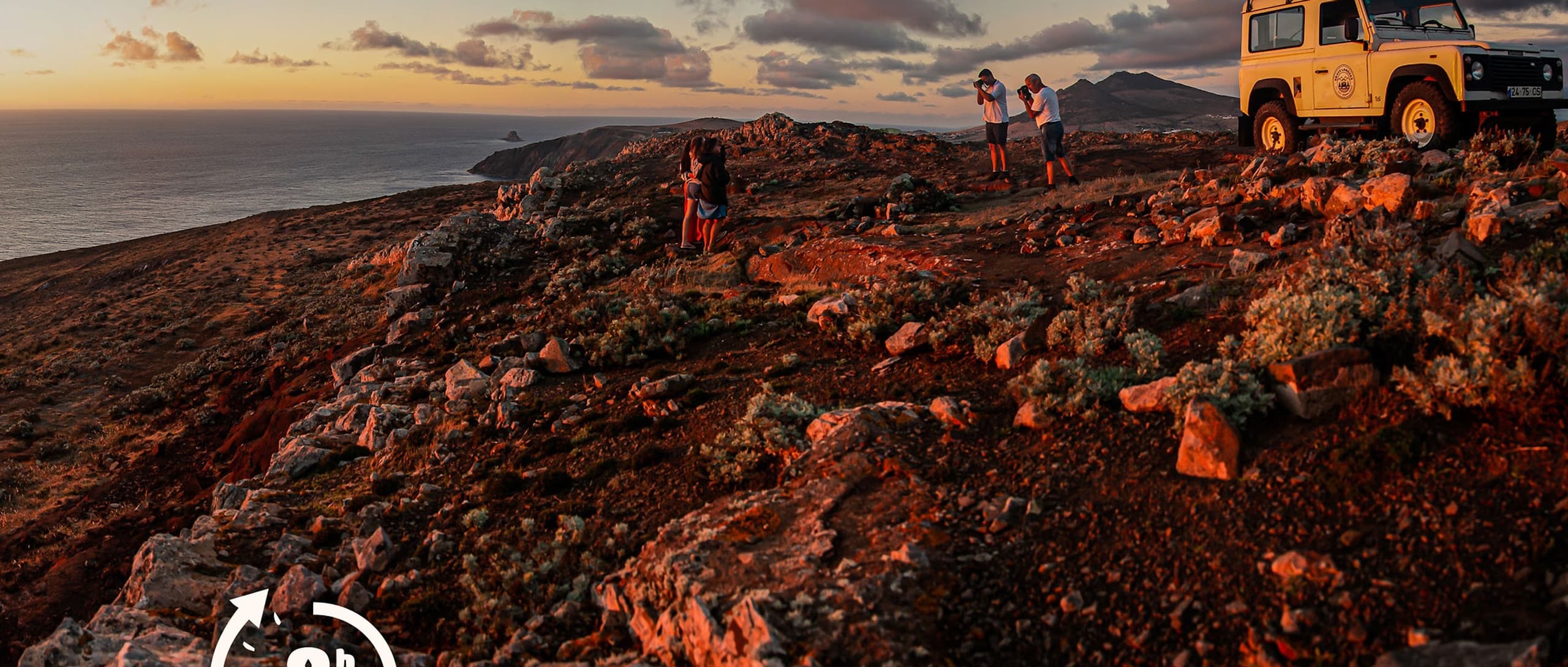 Off-road jeeps exploring rugged coastal lava fields at sunset