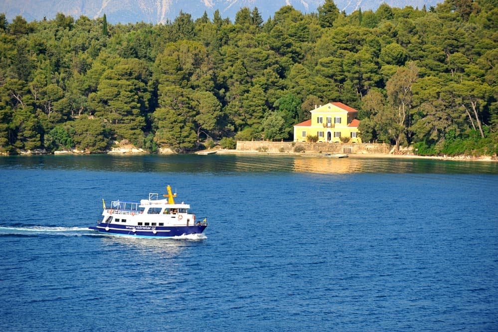 Tour boat cruising coastal waters past forested shoreline