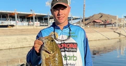 Fisherman showing bass near marina and calm shoreline