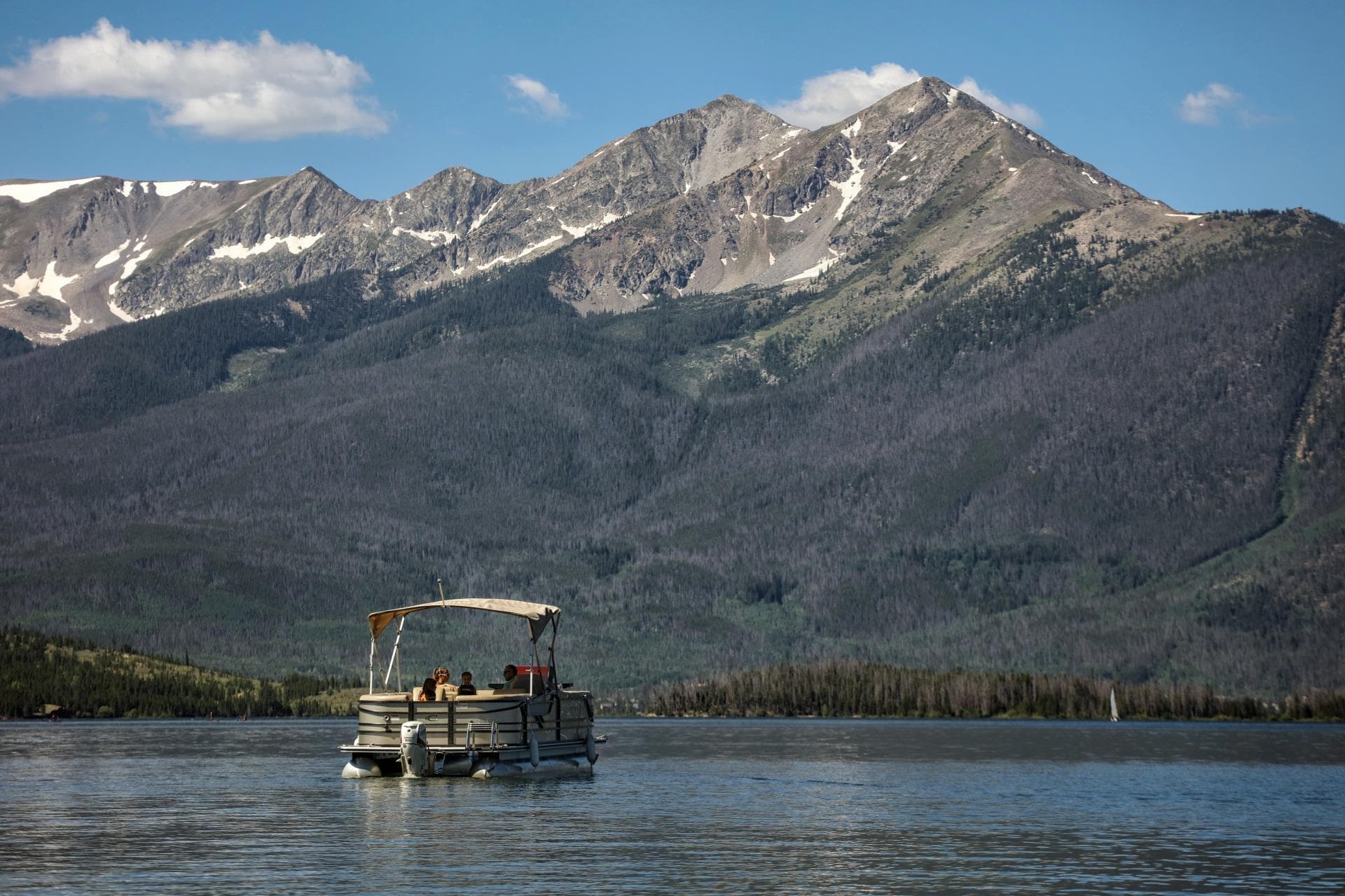 Pontoon boat cruising on Dillon Reservoir beneath peaks