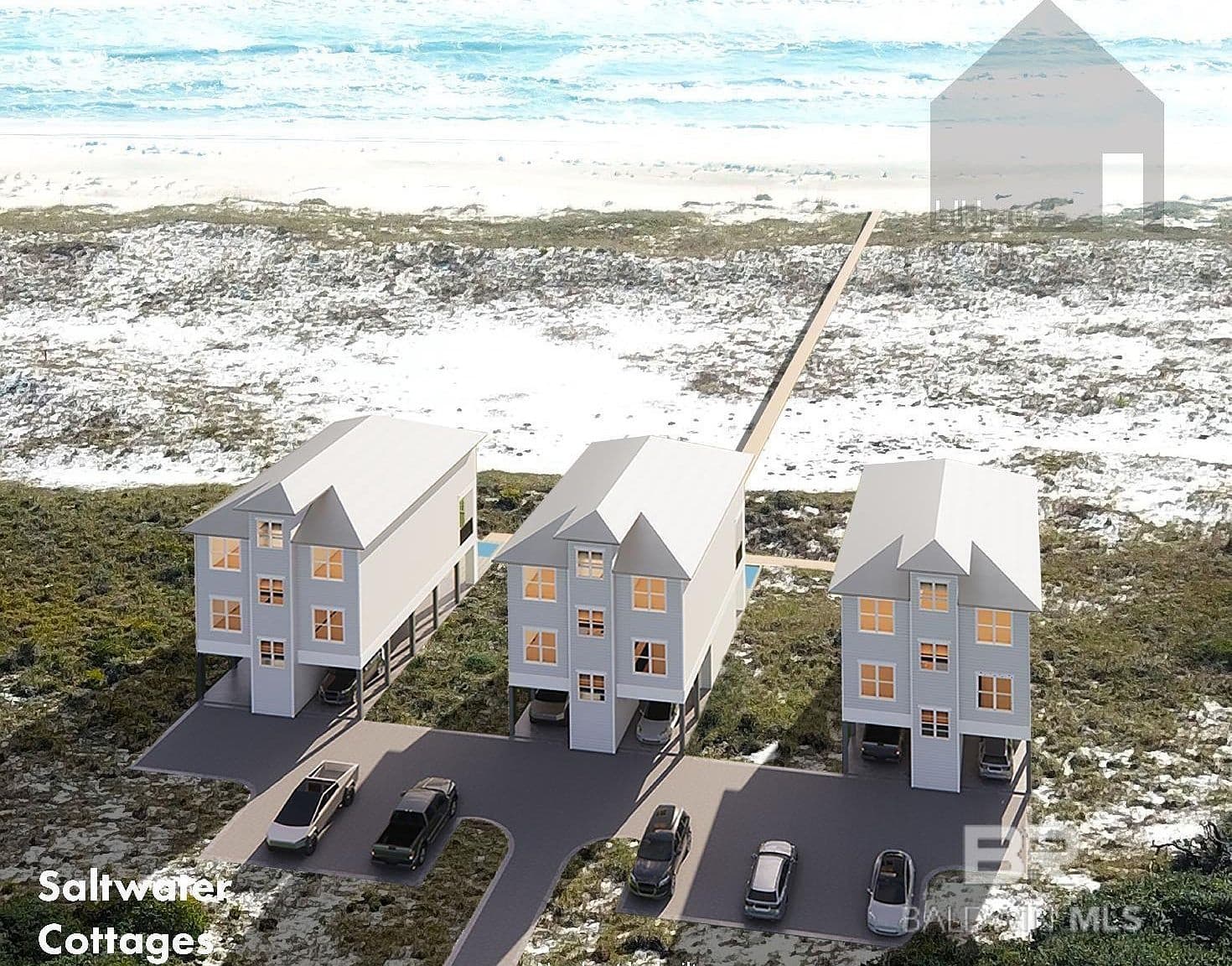 Row of elevated beach cottages on sand with pier and ocean view
