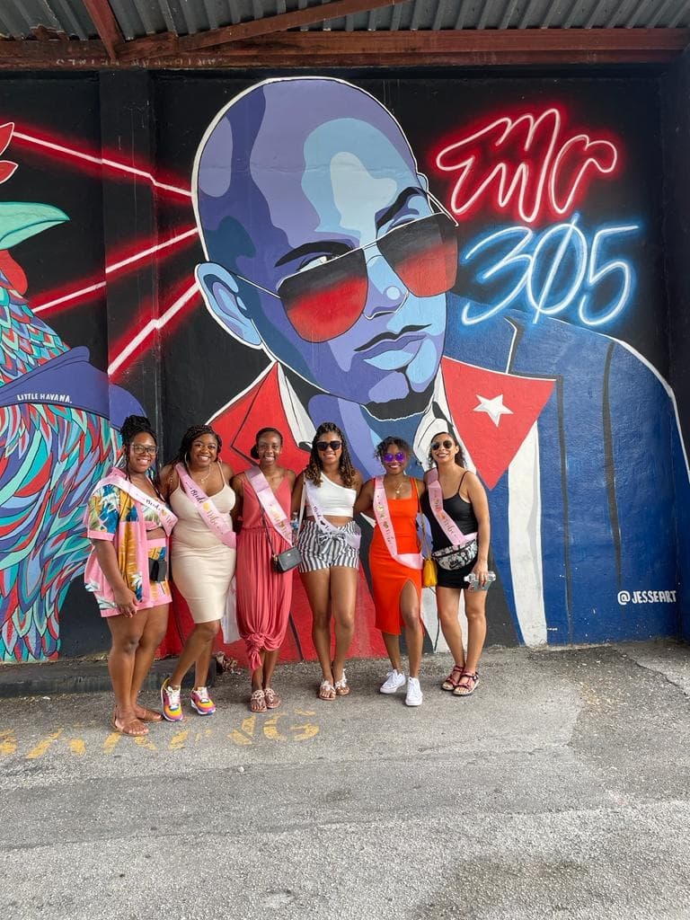 Group posing by colorful mural during Miami food walking tour