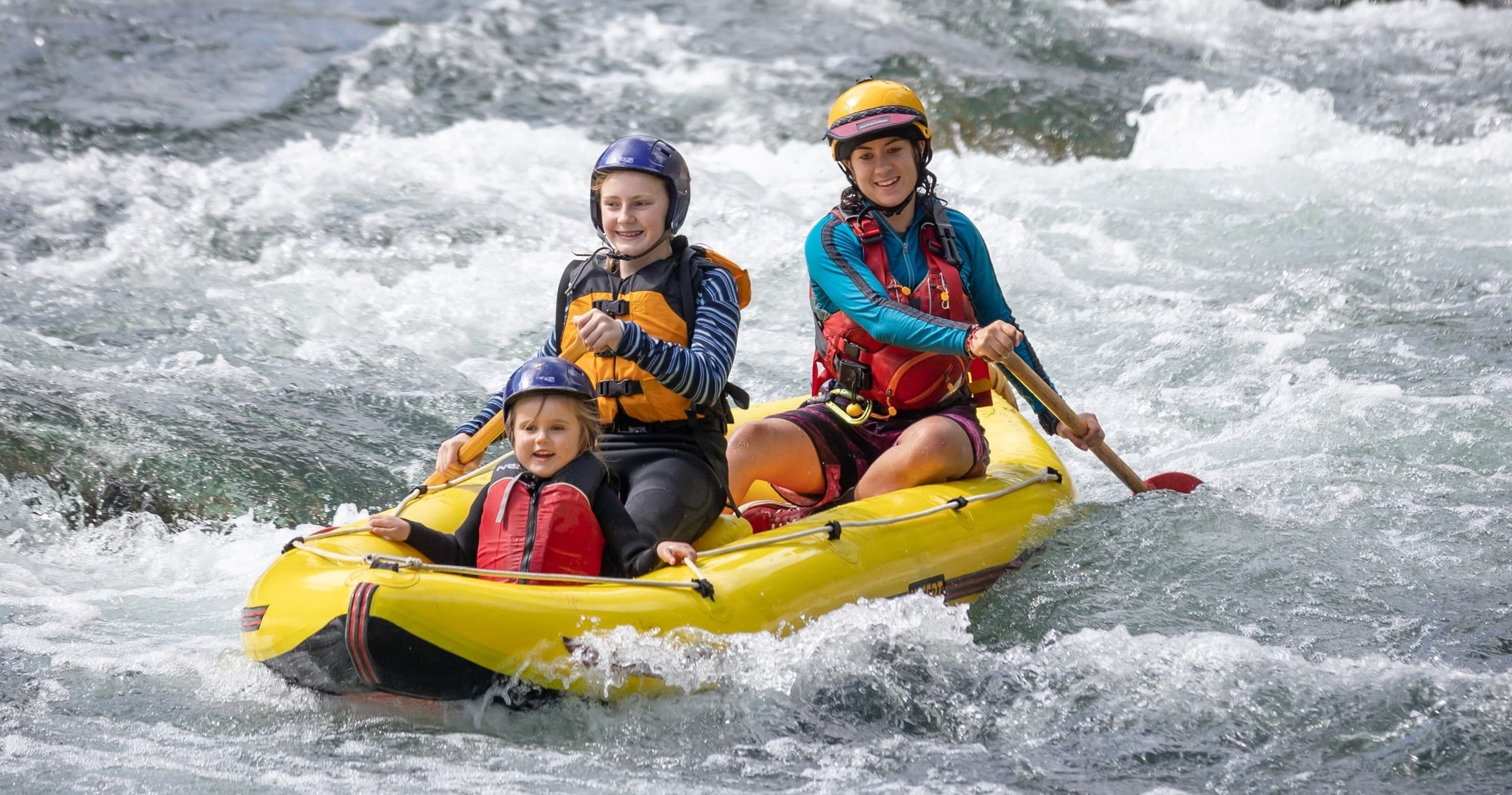 Two rafters tackling turbulent whitewater on river excursion