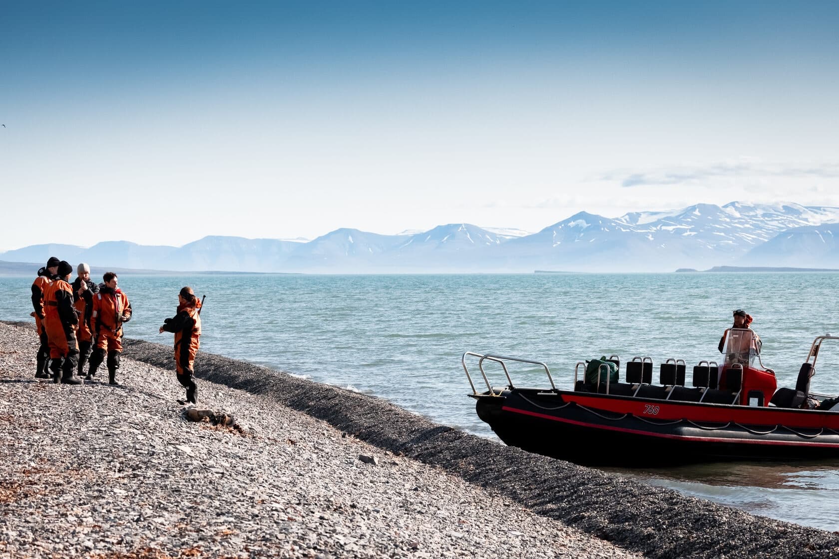 Guides and guests disembarking zodiac on Arctic pebble beach