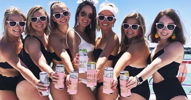 Group of women on party boat holding drinks during daytime cruise