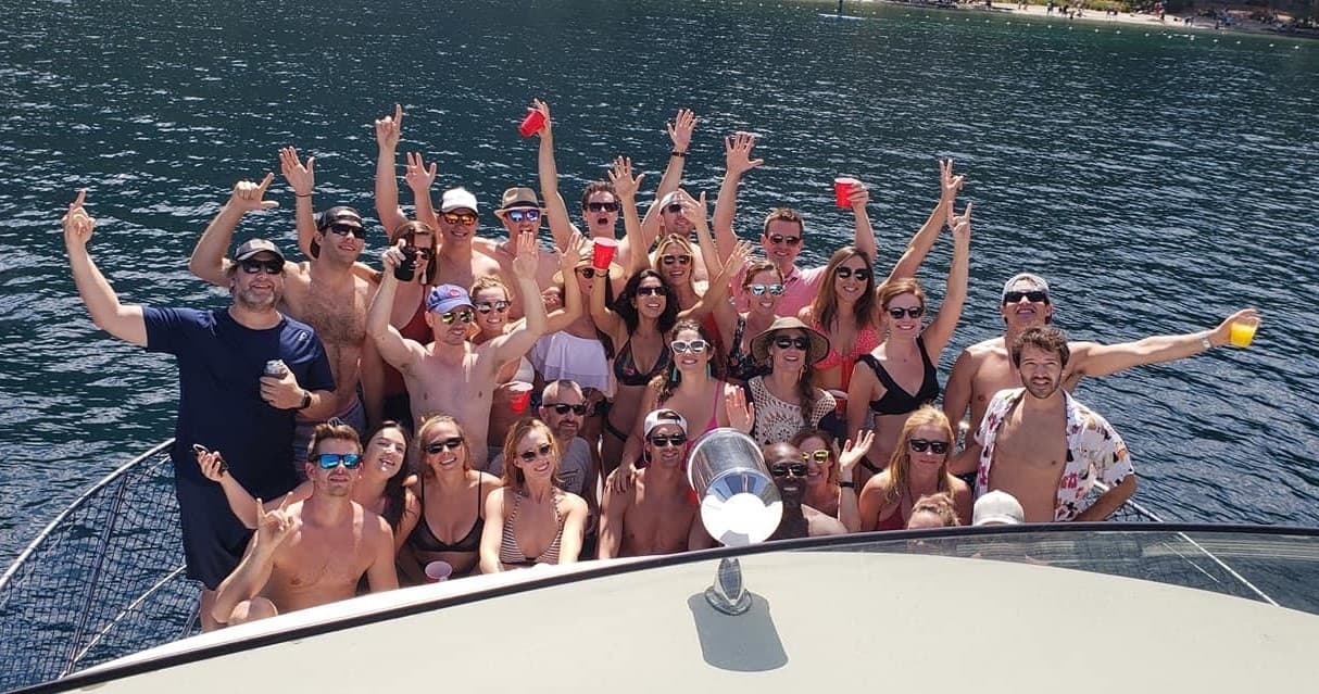 Crowd partying on bow of boat celebrating on lake waters