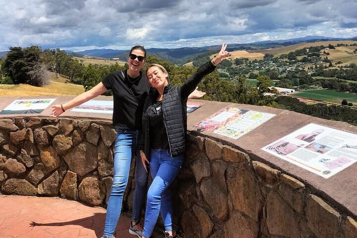 Visitors posing at scenic lookout over rolling countryside, Tasmania