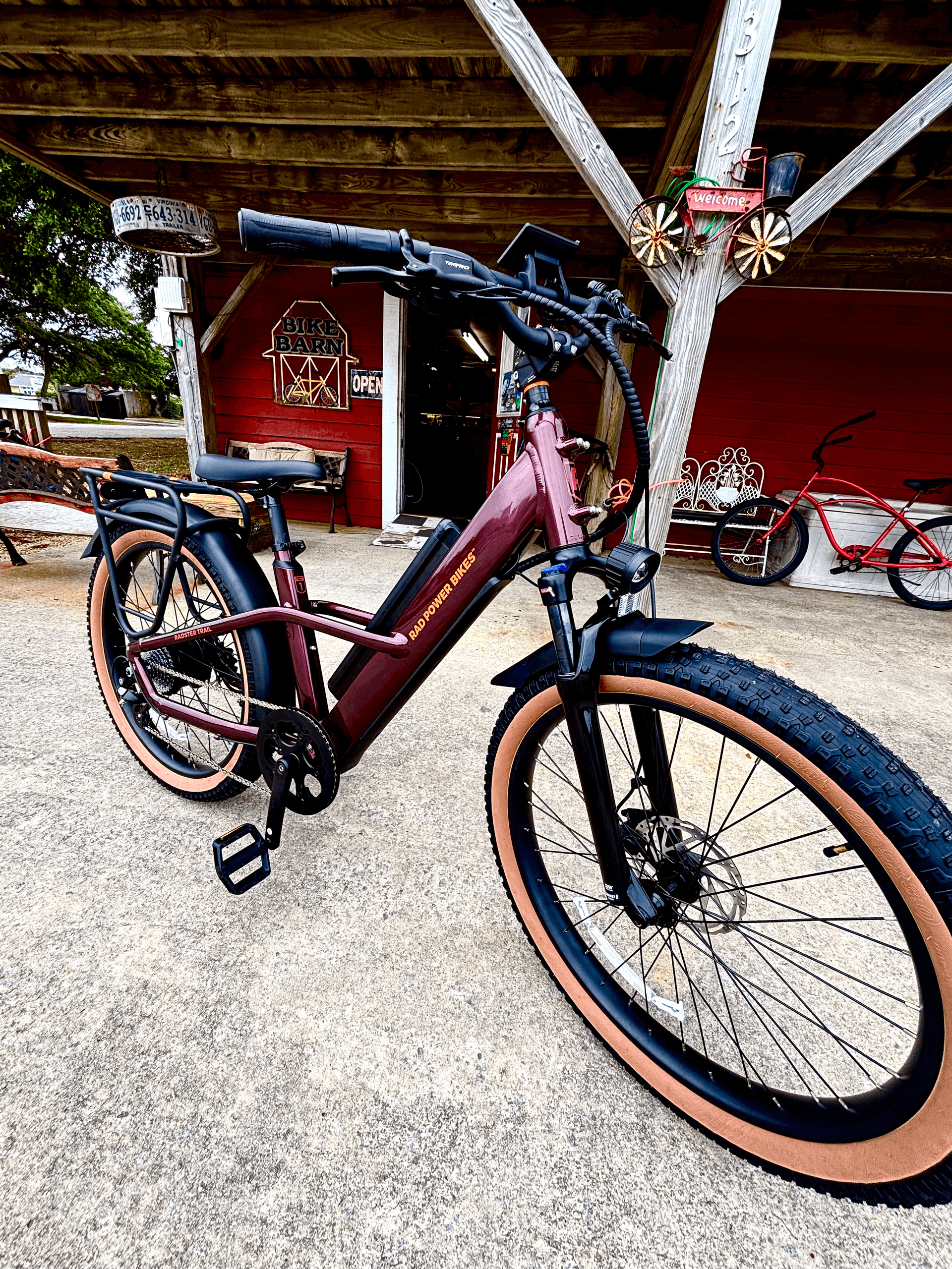 Ebike rental parked under wooden shelter near coastal shop