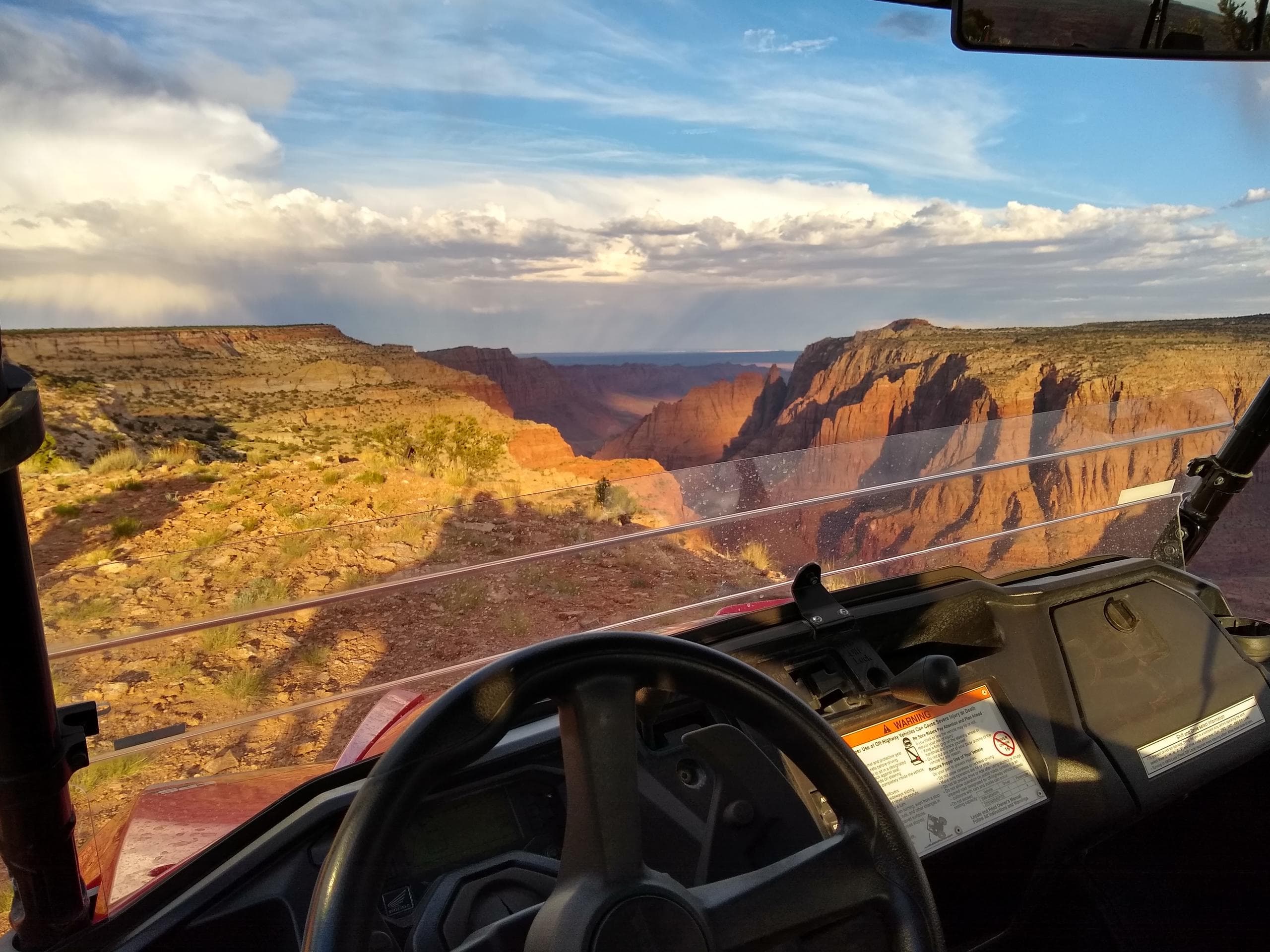 UTV cockpit overlooking dramatic canyon rim during off-road ride