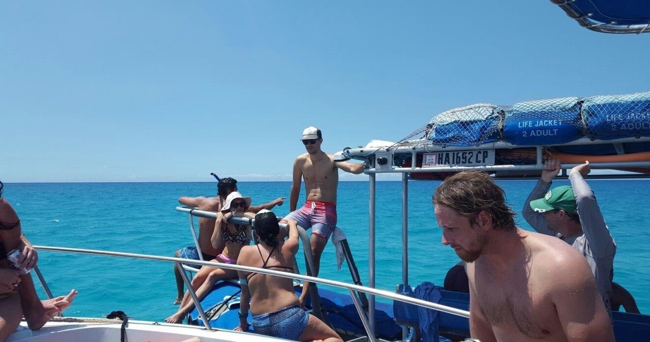 Boat tour on turquoise ocean with passengers preparing to snorkel