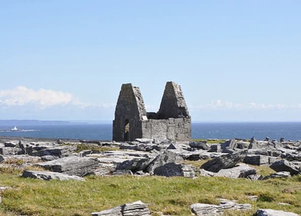 Ruined stone cottage on rocky Atlantic coastline overlooking sea
