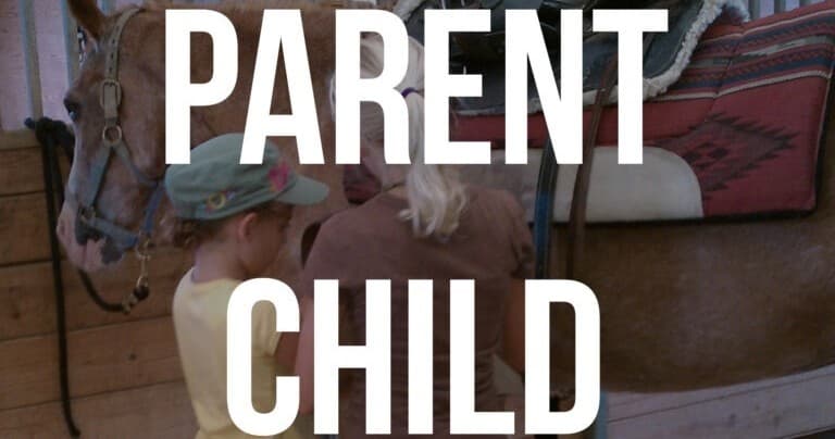 Parent and child grooming a horse in ranch stable session