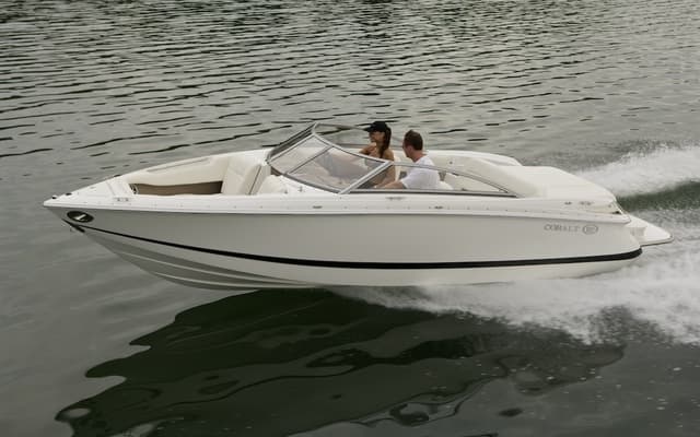 Recreational bowrider boat cutting through calm lake waters