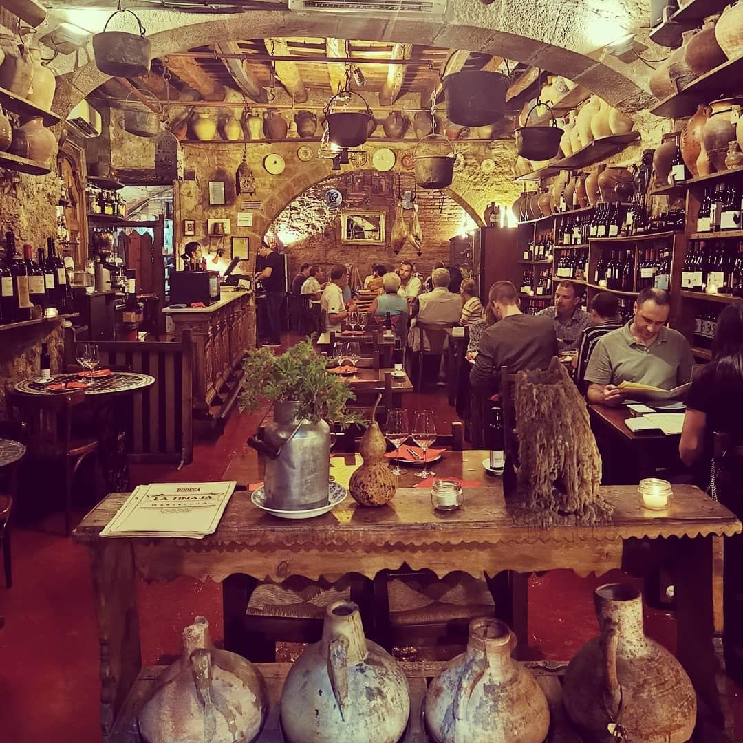 Rustic Born wine bar interior in Barcelona, patrons dining