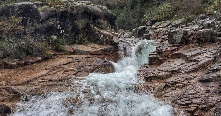 Rocky mountain stream flowing over cascades, wilderness trekking