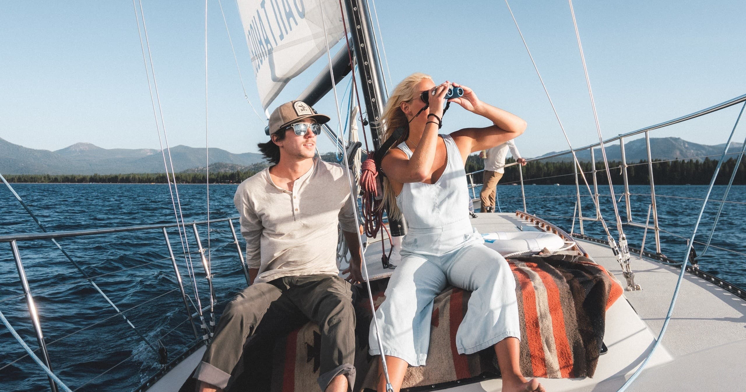 Couple enjoying sailing view from bow on clear mountain lake