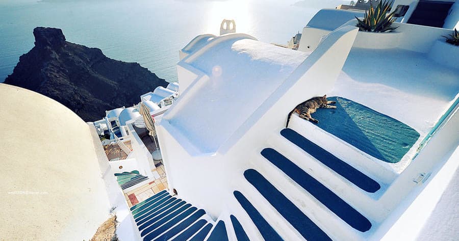 White Santorini terrace with stairs and pool overlooking caldera