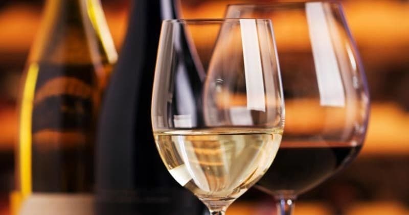 Close-up wine glasses and bottles suggesting tasting indoors