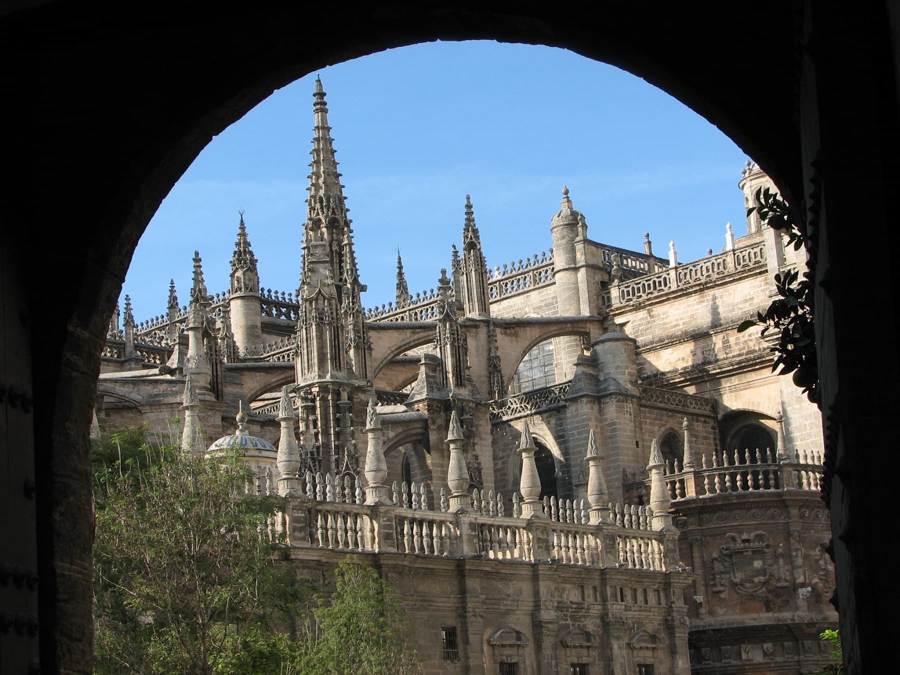 Panoramic view of Seville cathedral tower framed by archway