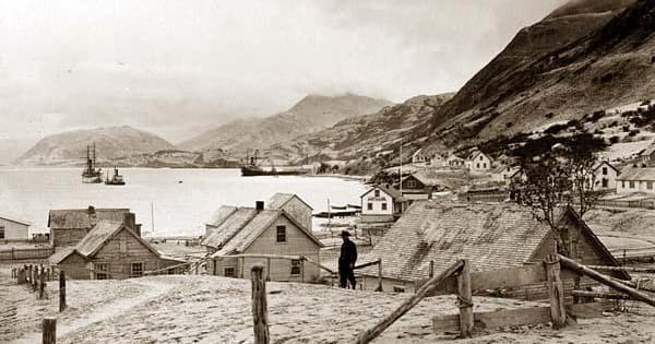 Historic waterfront village and harbor with mountains in background
