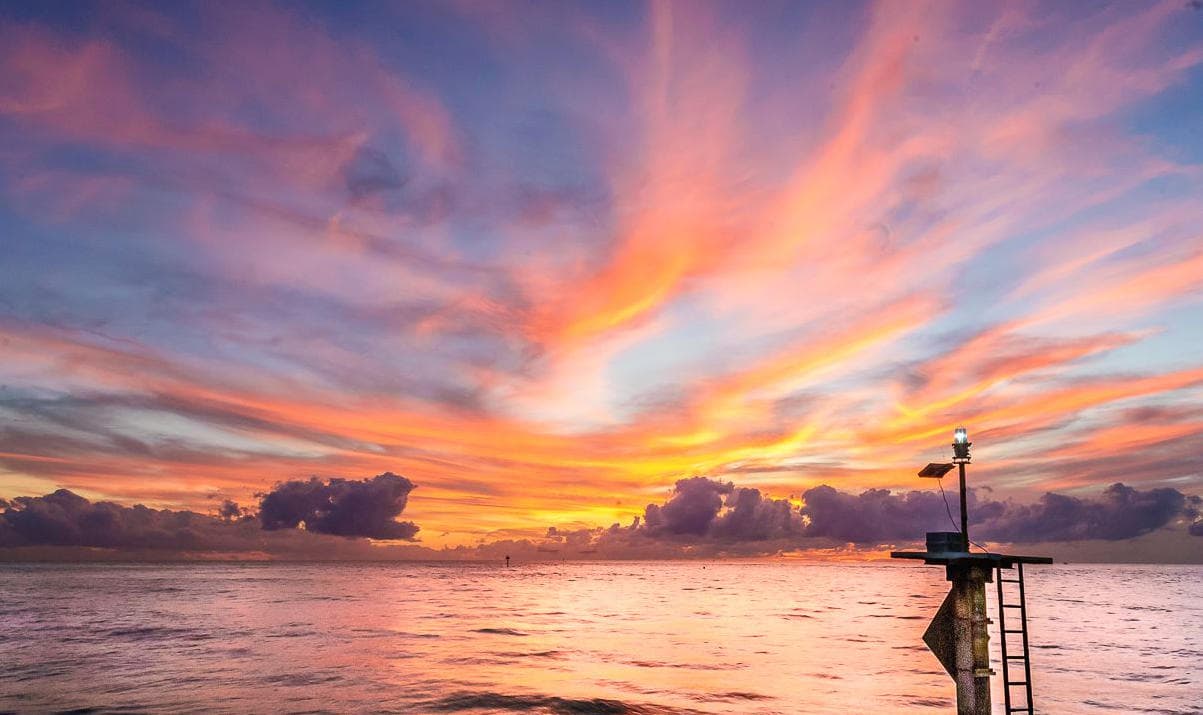 Vibrant ocean sunrise over pier for scenic coastal lookout