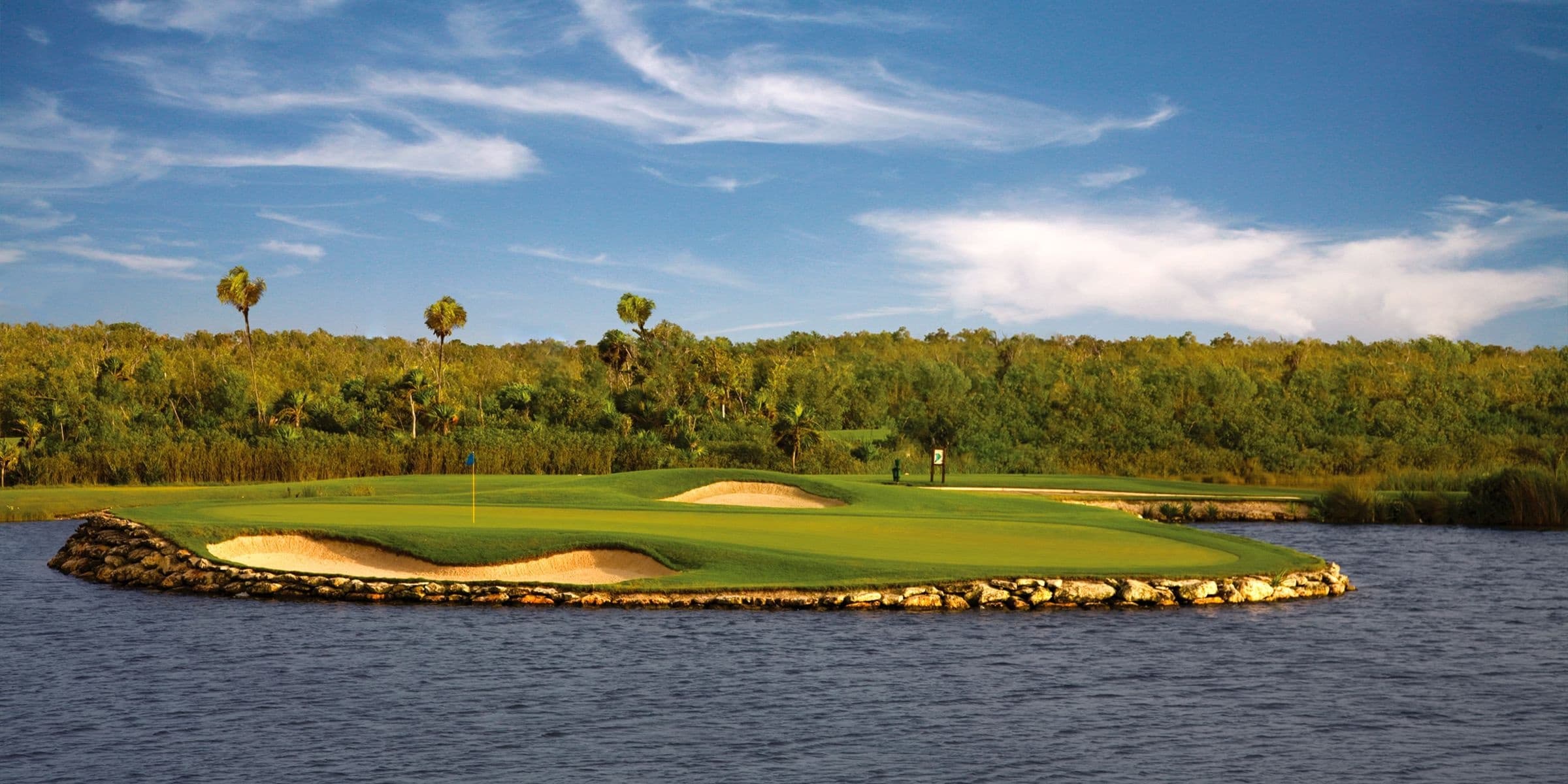 Golfer teeing off on panoramic links course by the ocean