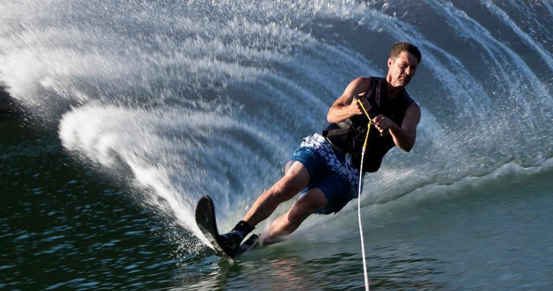 Water skier carving wake on lake, high-speed watersports action
