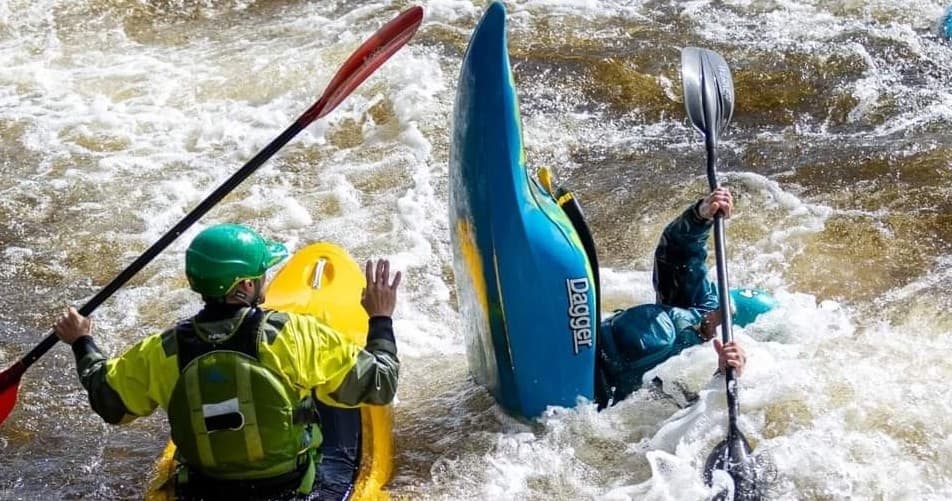 Whitewater kayakers navigating turbulent rapids, teamwork