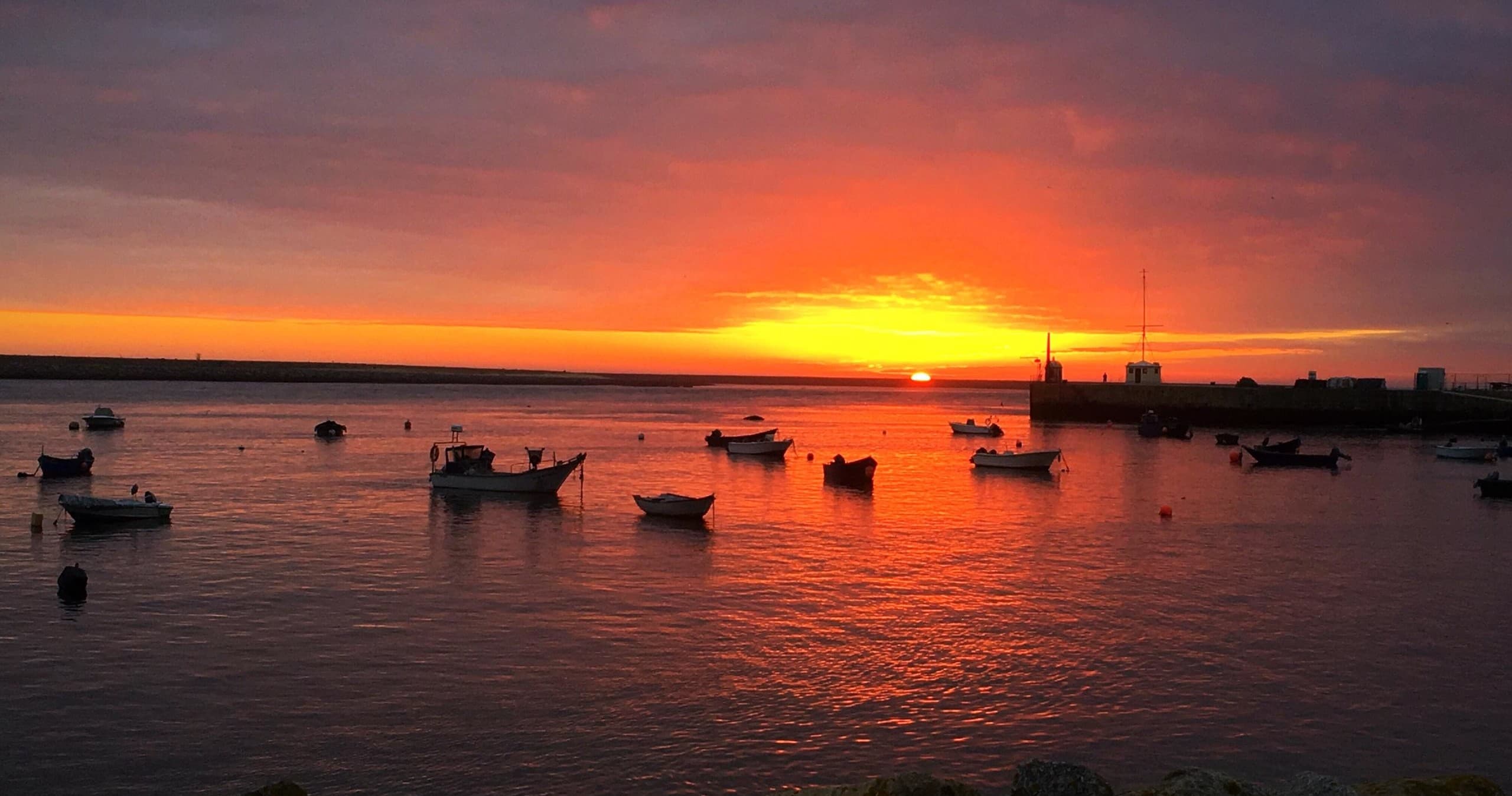 Boats at sunset in Porto harbor with golden sky reflection