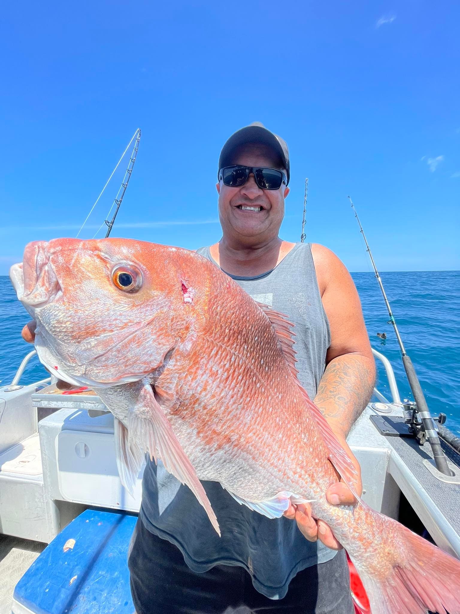 Angler holding large red snapper on ocean charter boat
