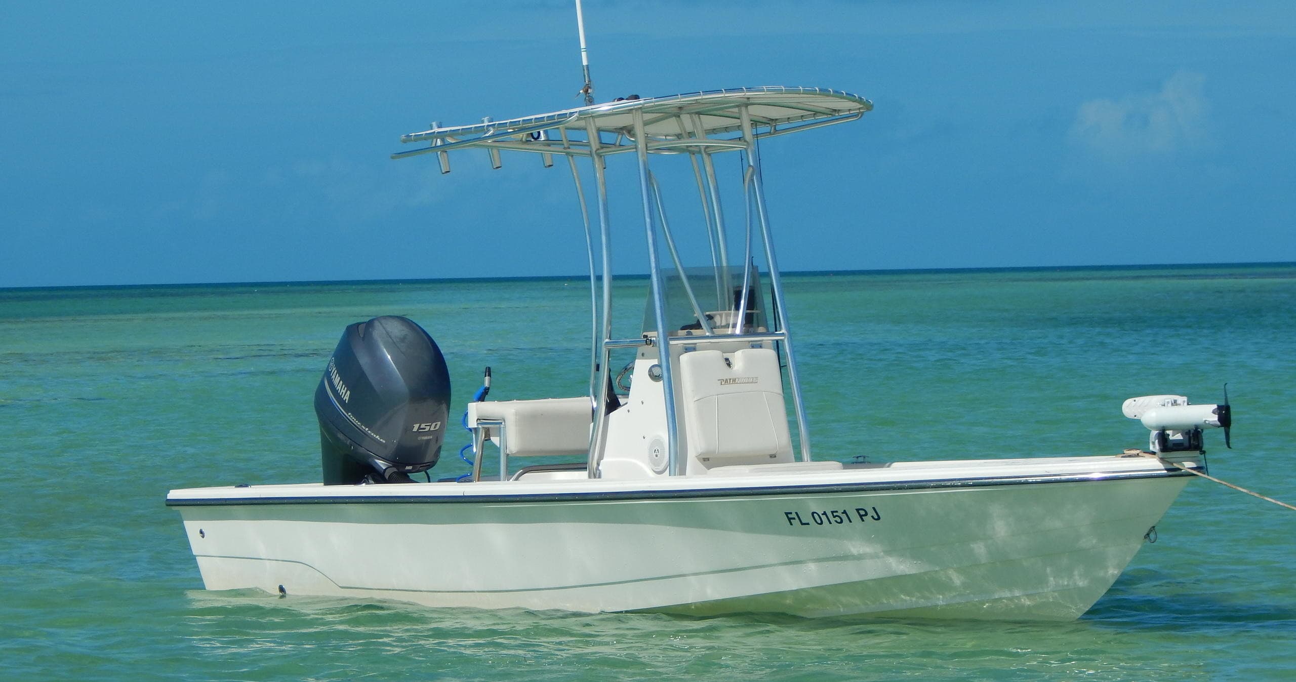 Shallow-water skiff moored over turquoise flats for Keys fishing trips