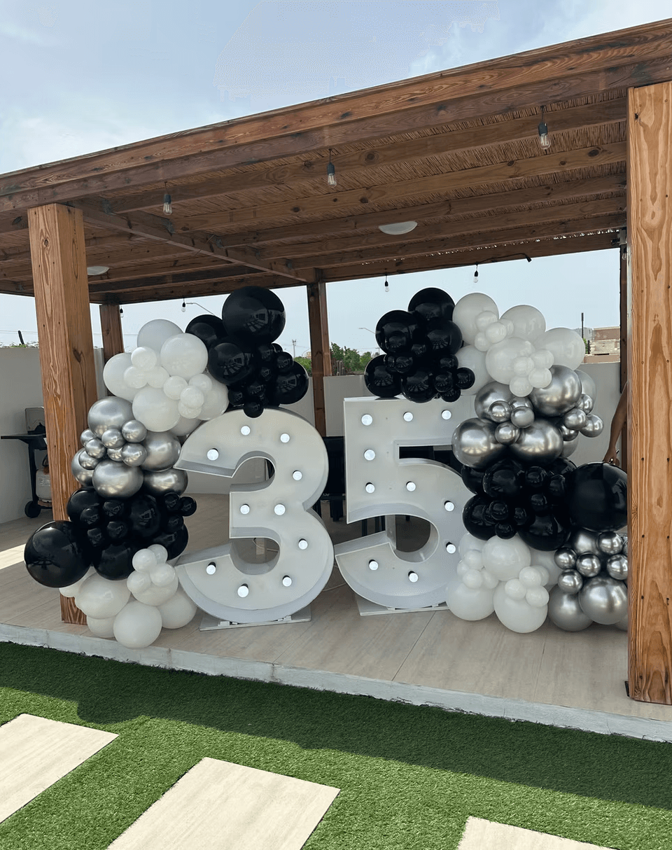 Outdoor 35th birthday balloon display under wooden pergola