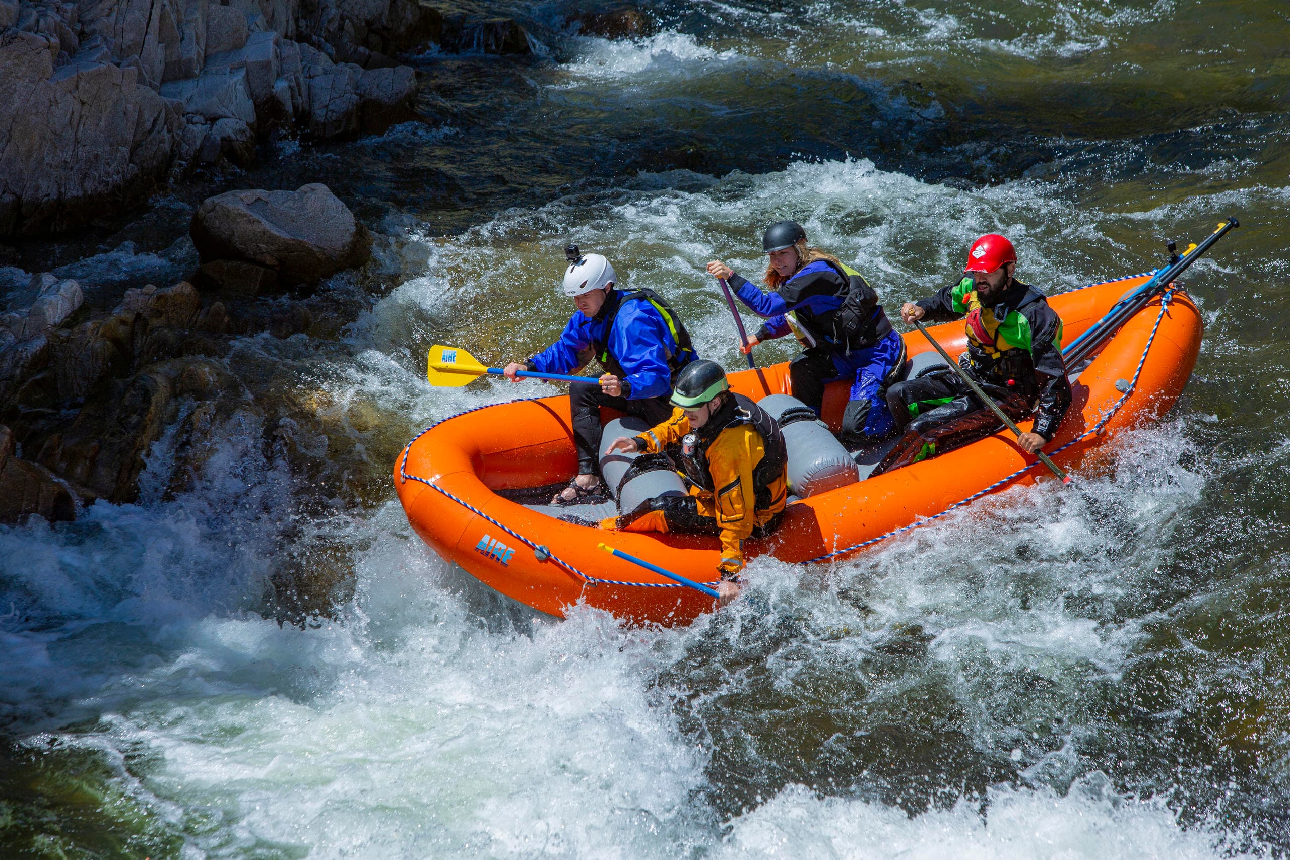 Whitewater rafters navigating turbulent river rapids in forest