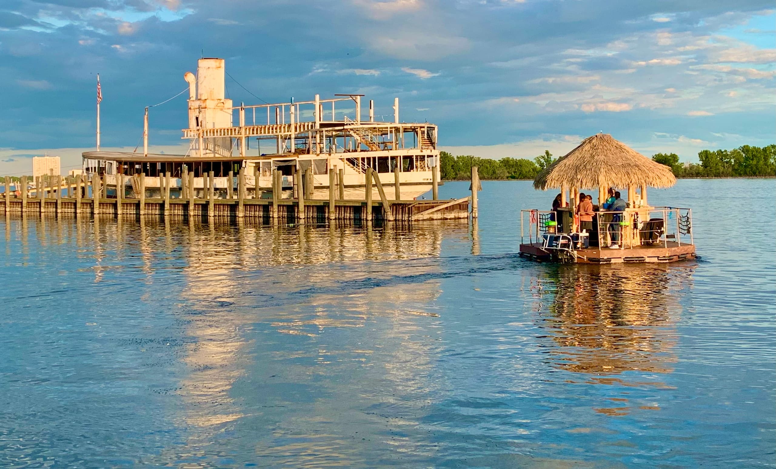 Sunset dock and tiki bar floating on calm river waters