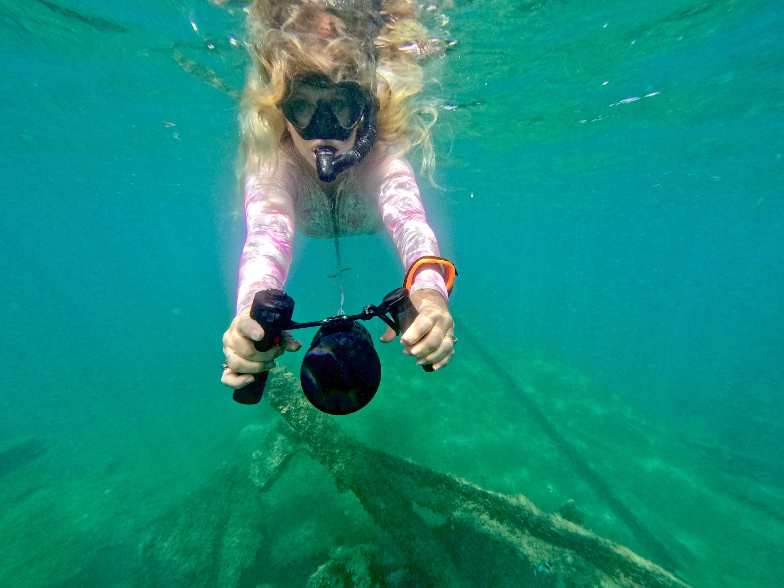Snorkeler diving with underwater camera above Hawaiian reef