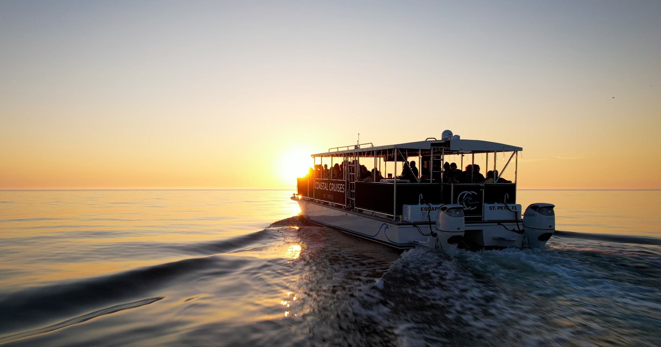Sunset boat cruising calm waters for coastal sightseeing cruise