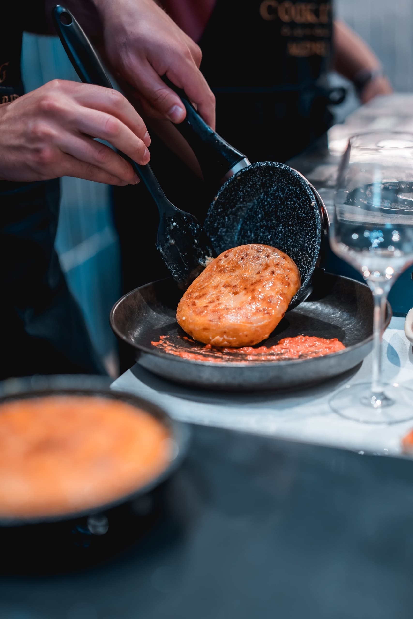 Chef cooking toasted bread in skillet at indoor cooking class