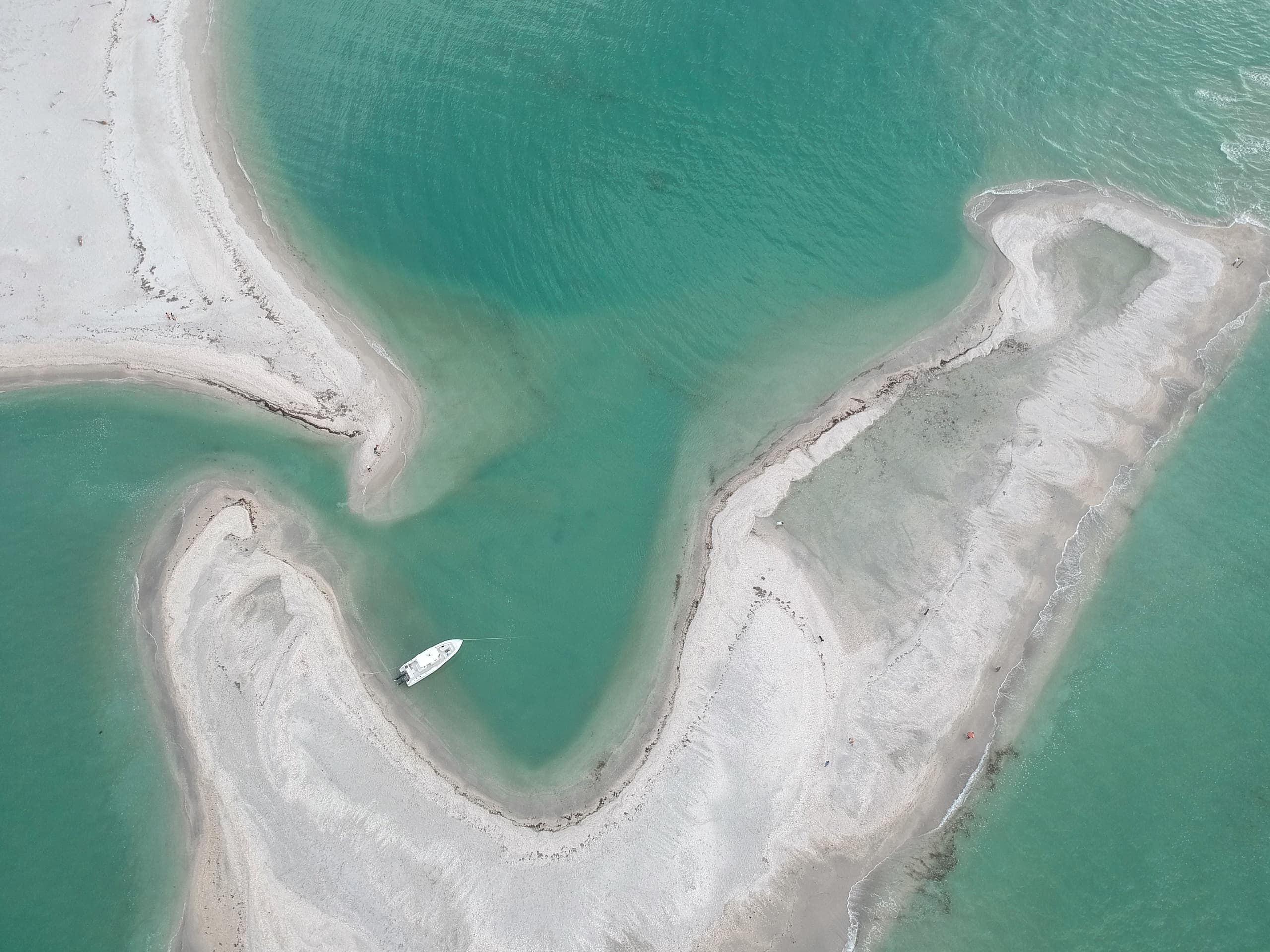 Aerial view of sandbar with anchored boat on turquoise Gulf