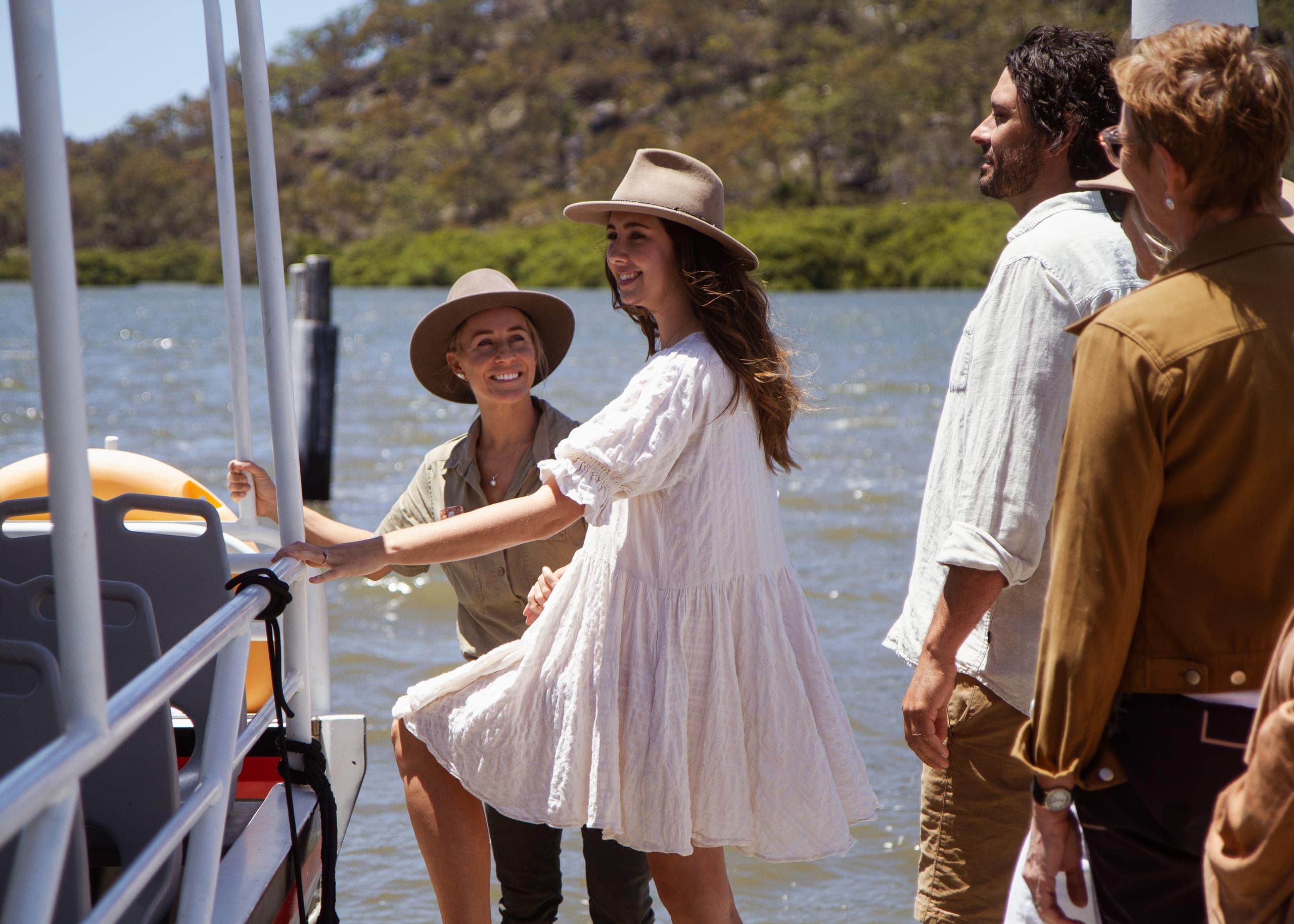 Guests boarding coastal eco-boat for oyster farm tour, smiling
